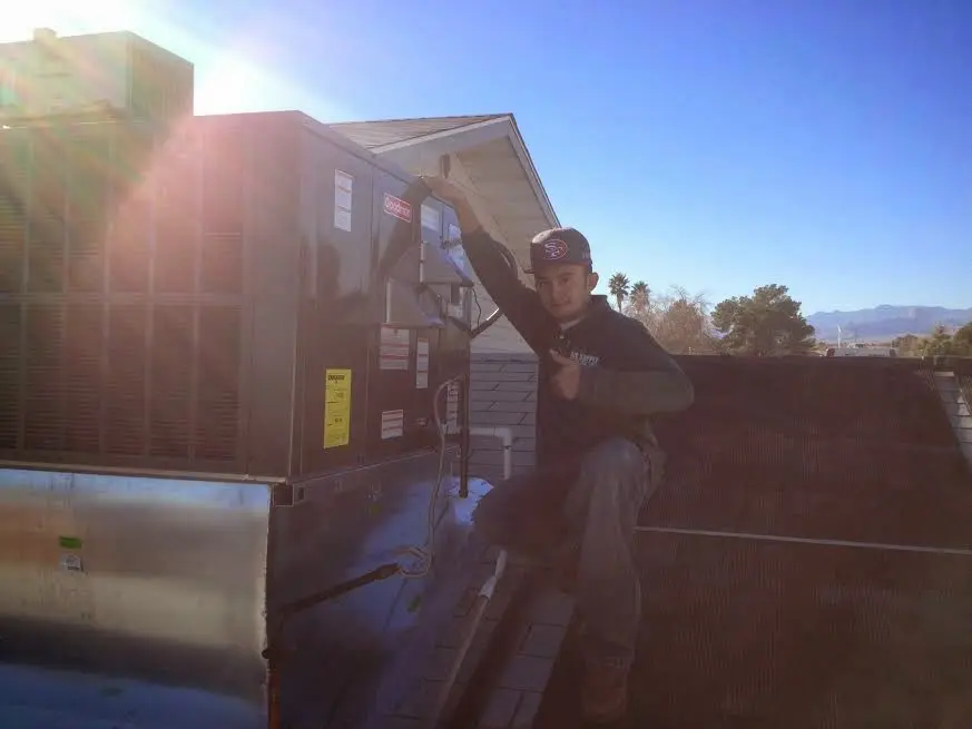 HVAC technician performing Boiler Repair on a rooftop unit in North East